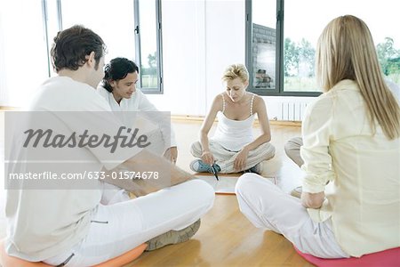 Group therapy, adults sitting in circle, one drawing on whiteboard