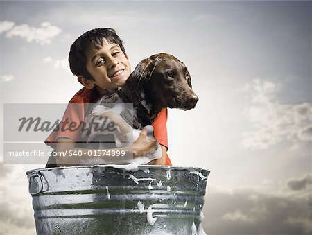 Lächelnde junge umarmt und Hund im Freien an wolkigen Tag Baden