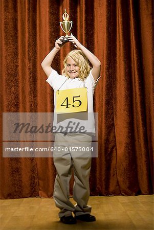 Girl contestant holding trophy and smiling