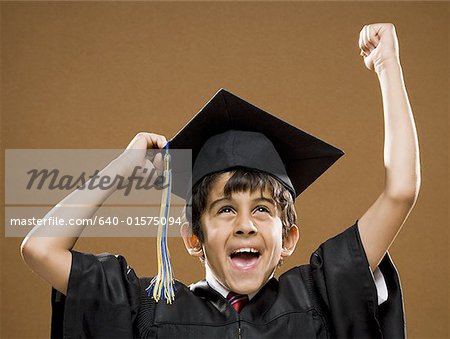 Boy graduate with mortar board smiling and cheering