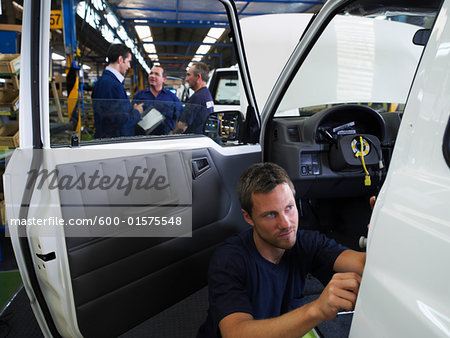 Man Working on Car in Factory