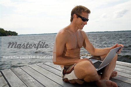Homme utilisant un ordinateur portable sur la station d'accueil