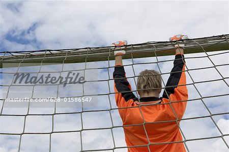 Goalkeeper hanging on goal