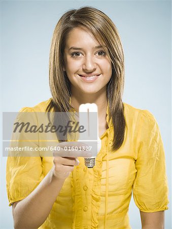 Woman holding fluorescent light bulb smiling