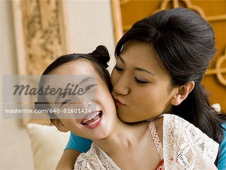 Mother giving daughter a kiss on cheek