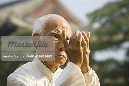 Man standing outdoors doing Kung Fu with ear buds