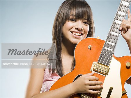 Frau lächelnd Gitarre spielen