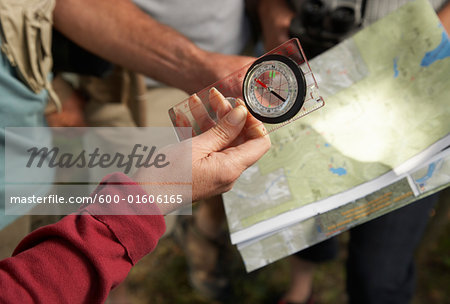 People in Woods with Compass and Map
