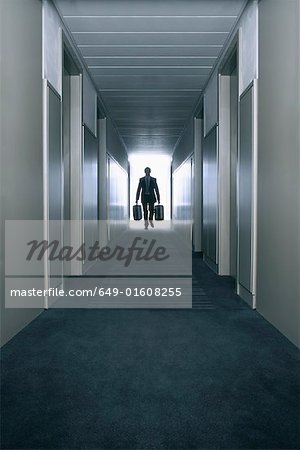Homme portant des valises dans un couloir