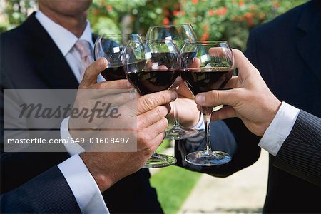 Quatre hommes d'affaires, boire du vin dans un jardin