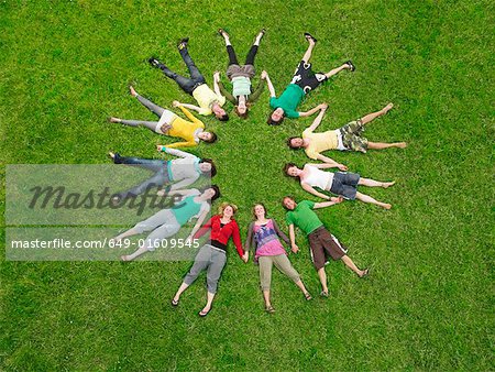 Crowd lying in grass in circle