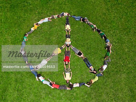 Group lying on grass in a peace sign formation