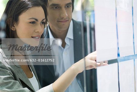 Young couple looking at window of real estate agency