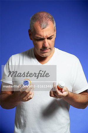 Man Looking at Pill Containers