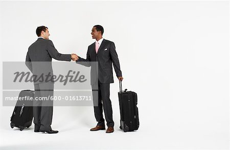 Businessmen With Luggage Shaking Hands