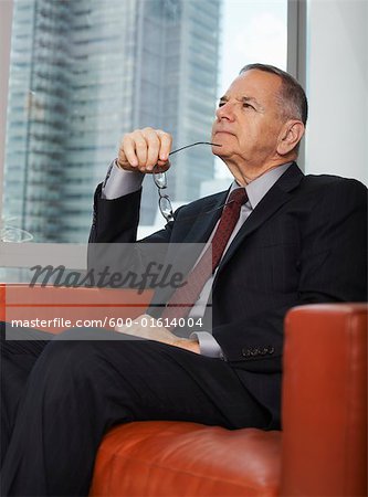 Businessman Sitting on a Sofa Looking Thoughtful
