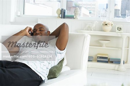 Man Lying on Sofa, Talking on Cellular Phone