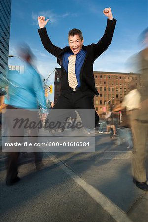 Businessman Jumping for Joy at Downtown Intersection
