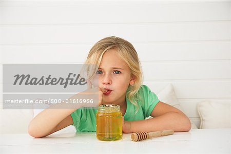 Petite fille mangeant miel