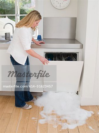 Woman opening a leaking dishwasher