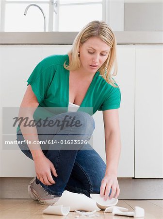 Woman picking up broken vase