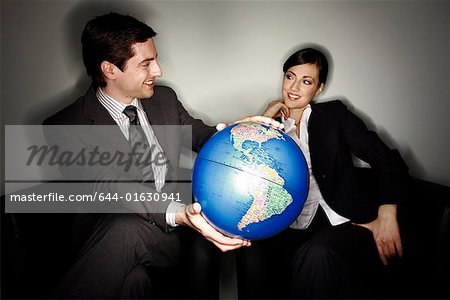 Male and female businesspeople with globe