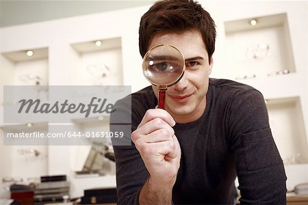 Man with magnifying glass on eye
