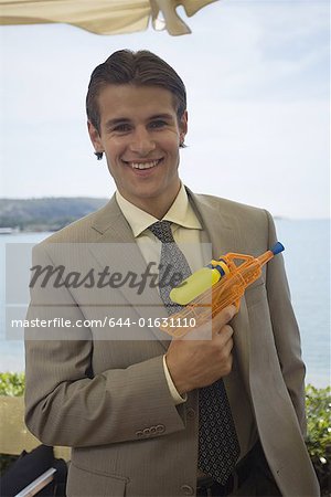 Homme d'affaires avec pistolet à eau en plastique