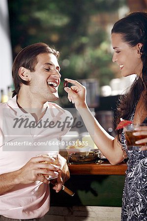Woman feeding man in a bar
