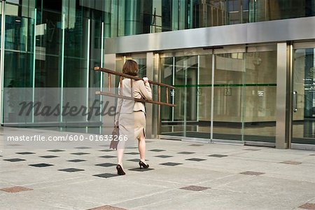 Businesswoman Entering Building, Holding Ladder