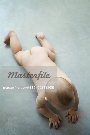 Naked baby crawling on floor, full length, viewed from directly above