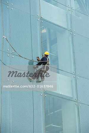 Window washer on side of office building, close-up