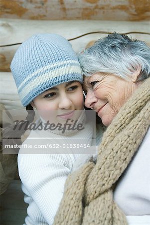 Grandmother and granddaughter, smiling, cheek to cheek, portrait