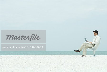 Geschäftsmann mit Laptop-Computer, auf dem Strand, in voller Länge