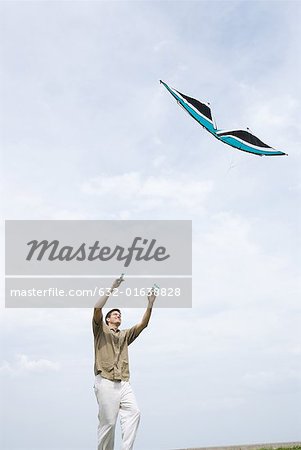 Man flying kite, low angle view