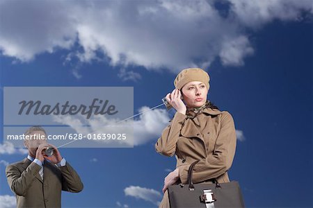 Business couple talking with tin can phone