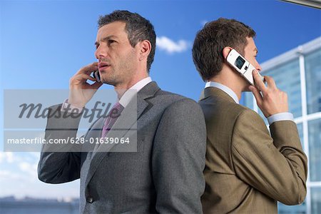 Deux hommes d'affaires téléphoner avec les téléphones mobiles