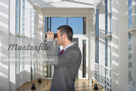 Businessman looking through field glasses