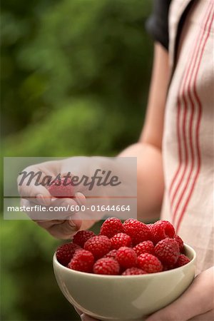 Close-up of Woman Holding Bowl of Raspberries