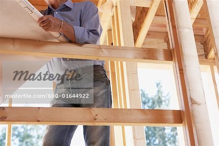 Man with Blueprint on Construction Site