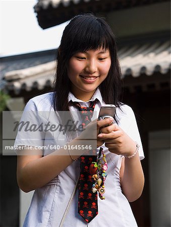 Adolescente en uniforme scolaire, sourire avec lecteur mp3