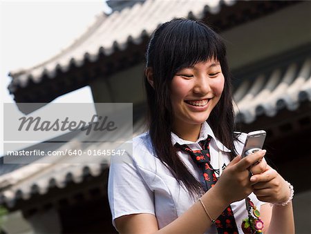 Teenager-Mädchen in Schuluniform lächelnd mit mp3-player