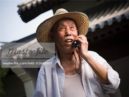 Mature man talking on cell phone outdoors smiling