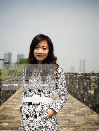 Woman standing on stone bridge smiling