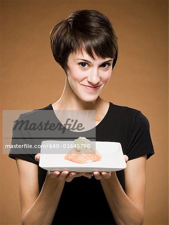 Frau hält lächelnd sushi