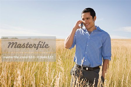 Man Using Cellphone in Field