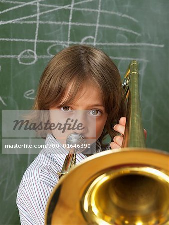 Boy Playing Trombone in Classroom