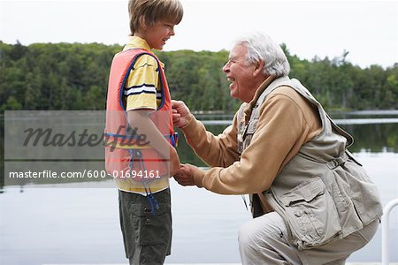 Mann helfen jungen mit Schwimmweste