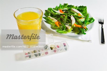 Hähnchen-Salat, Orangensaft und Pille-Dispenser