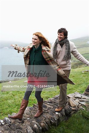 Couple marchant le long du mur de pierre, Irlande
